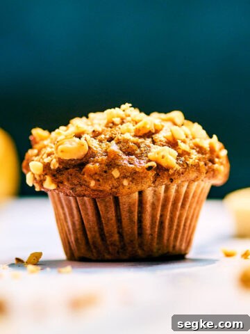 Banana Nut Bread Mini Muffin topped with chopped walnuts.