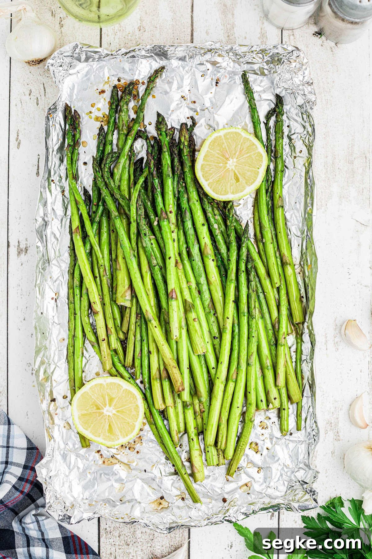 How to Smoke Asparagus: Tender, Smoky Grilled Spears 2 overhead close up of some smoked asparagus with some lemon on the sides.
