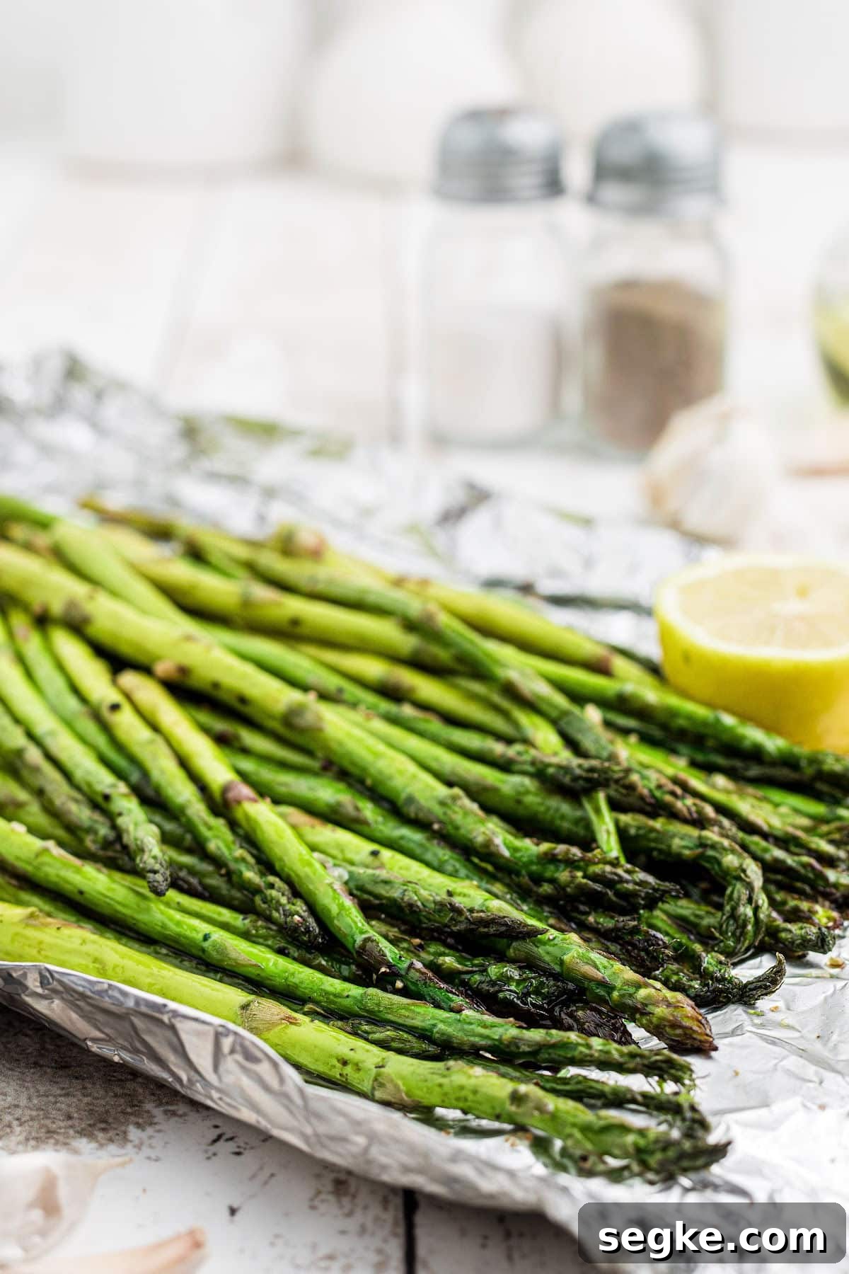 How to Smoke Asparagus: Tender, Smoky Grilled Spears 4 overhead close up of some smoked asparagus with some lemon on the sides.