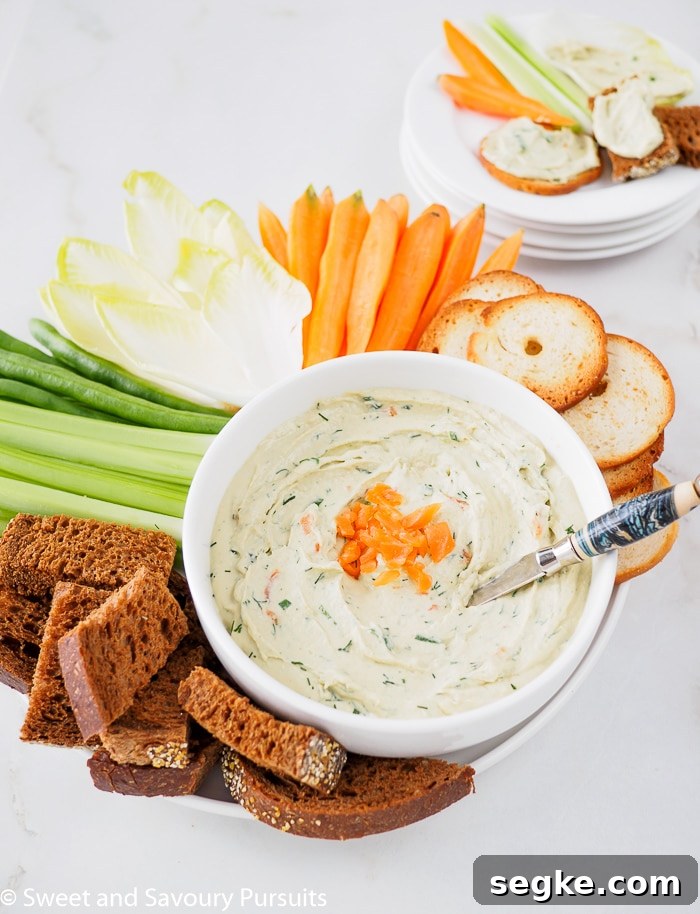 Smoked Salmon and Cream Cheese Dip 4 Close-up of a Smoked Salmon Dip served with fresh vegetables, bagel crisps and pumpernickel bread.