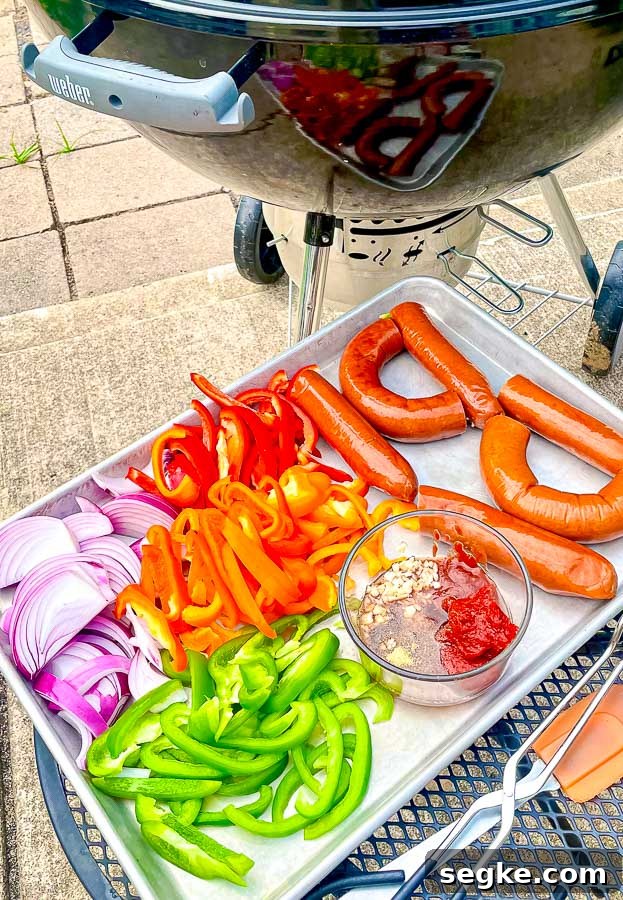 Grilled Sausage with Peppers and Onions Recipe 4 ingredients for grilled sausage with onions and peppers next to a weber grill