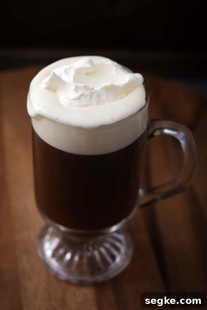 How to Make Classic Irish Coffee 2 Classic Irish Coffee Recipe in a glass on a wooden board
