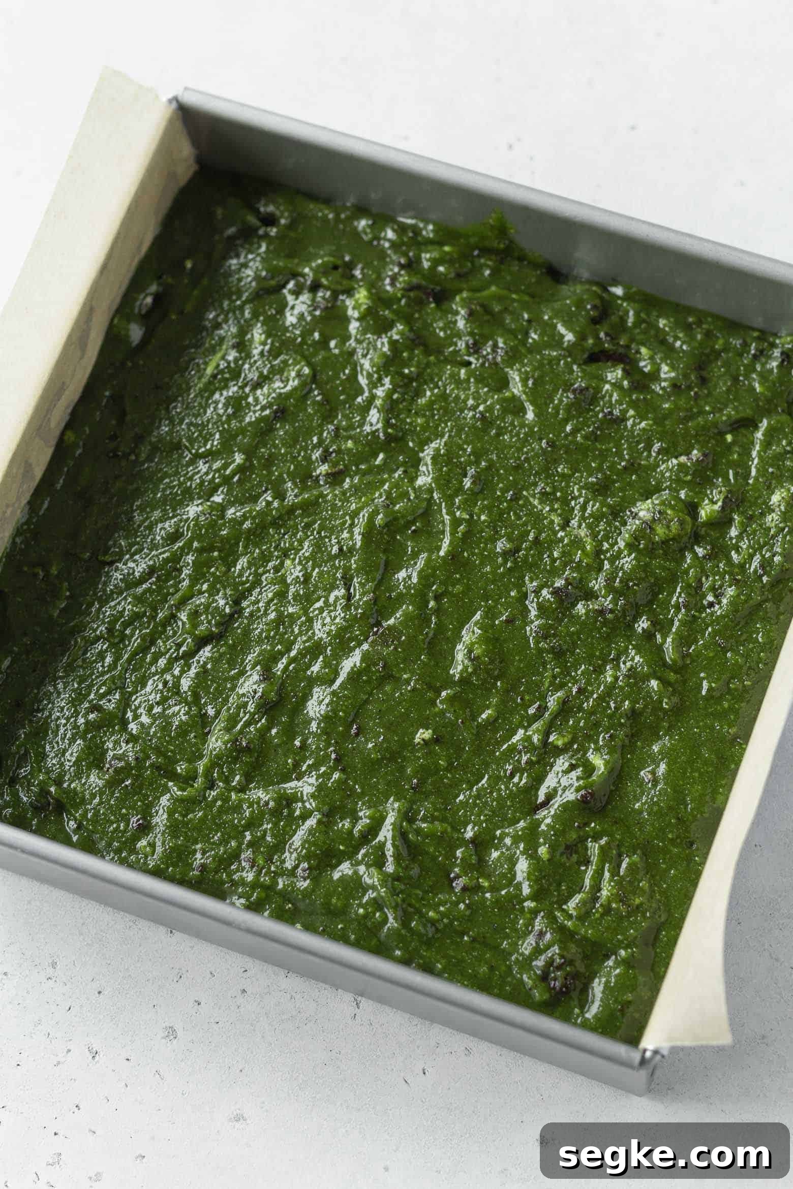 Matcha blondie batter in a square pan