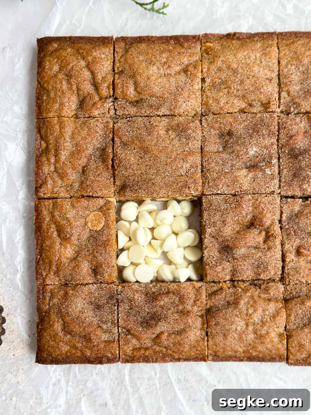 Gingerbread Blondies Recipe: Molasses-Spiced Chewy Bars 3 a close up of the gingerbread blondies with one square missing and the spot filled with white chocolate chips.