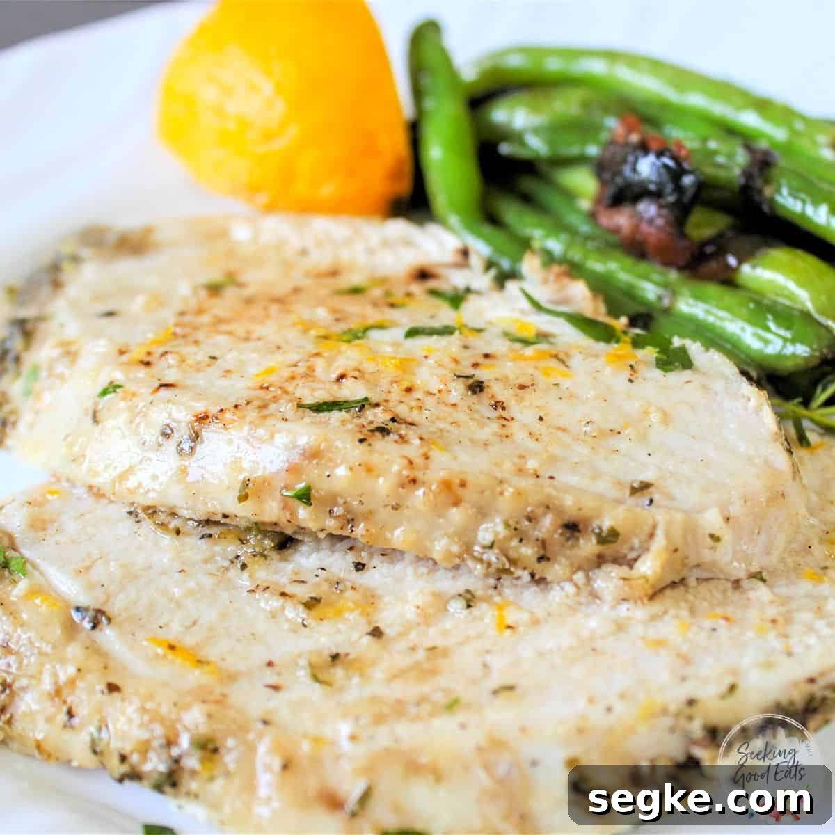 Cooked and sliced juicy slow cooker turkey breast on a white plate.