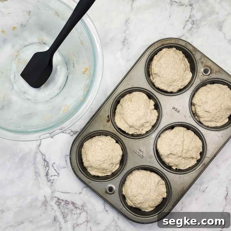Flaky Mozzarella-Stuffed Whole-Wheat Biscuits Recipe 7 Overhead view of process shot 4 - distribute the remaining dough among the muffin cups, gently pressing the dough down around the cheese.