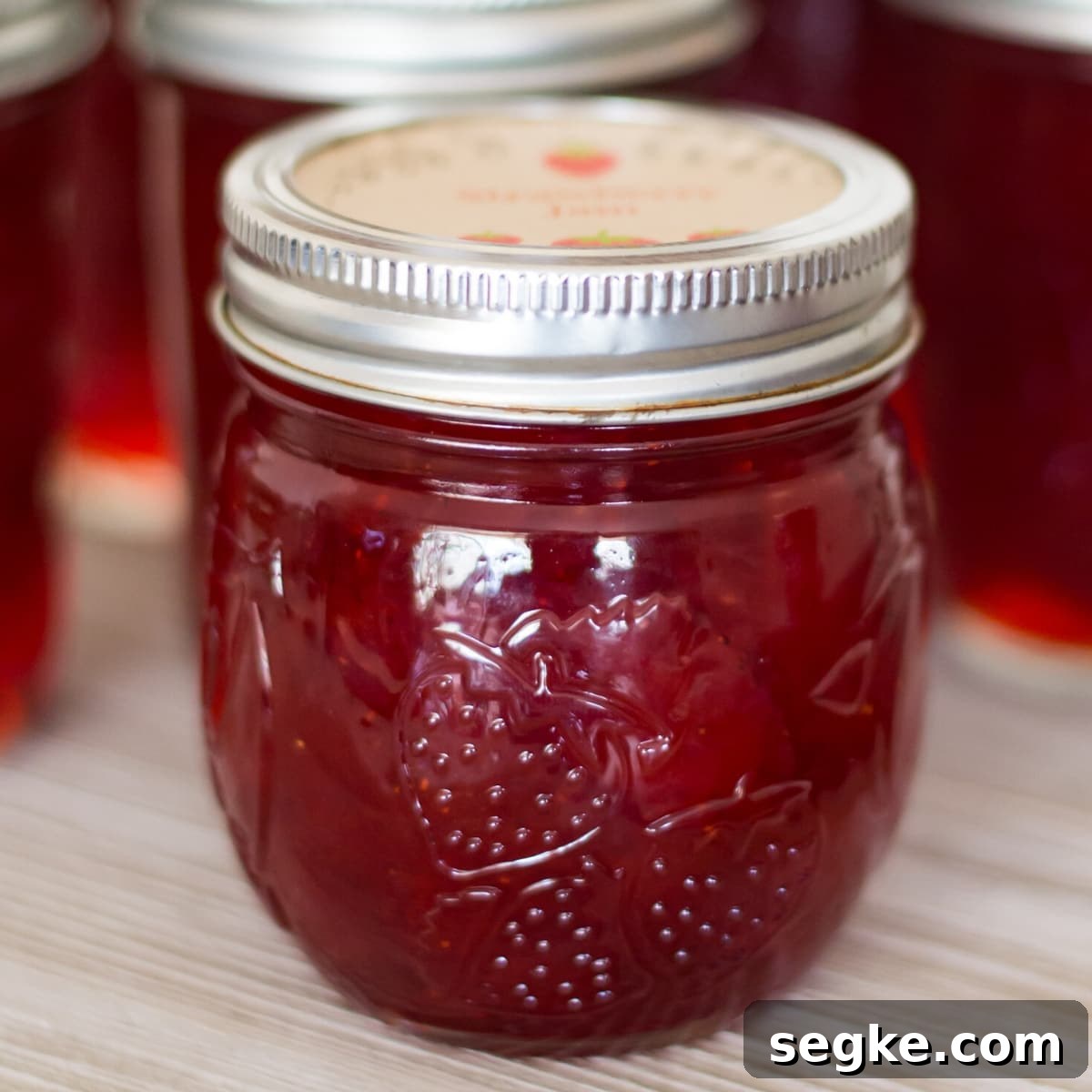 How to Can Strawberries: Recipes and Canning Tips 6 closeup of a canning jar filled with homemade strawberry jam