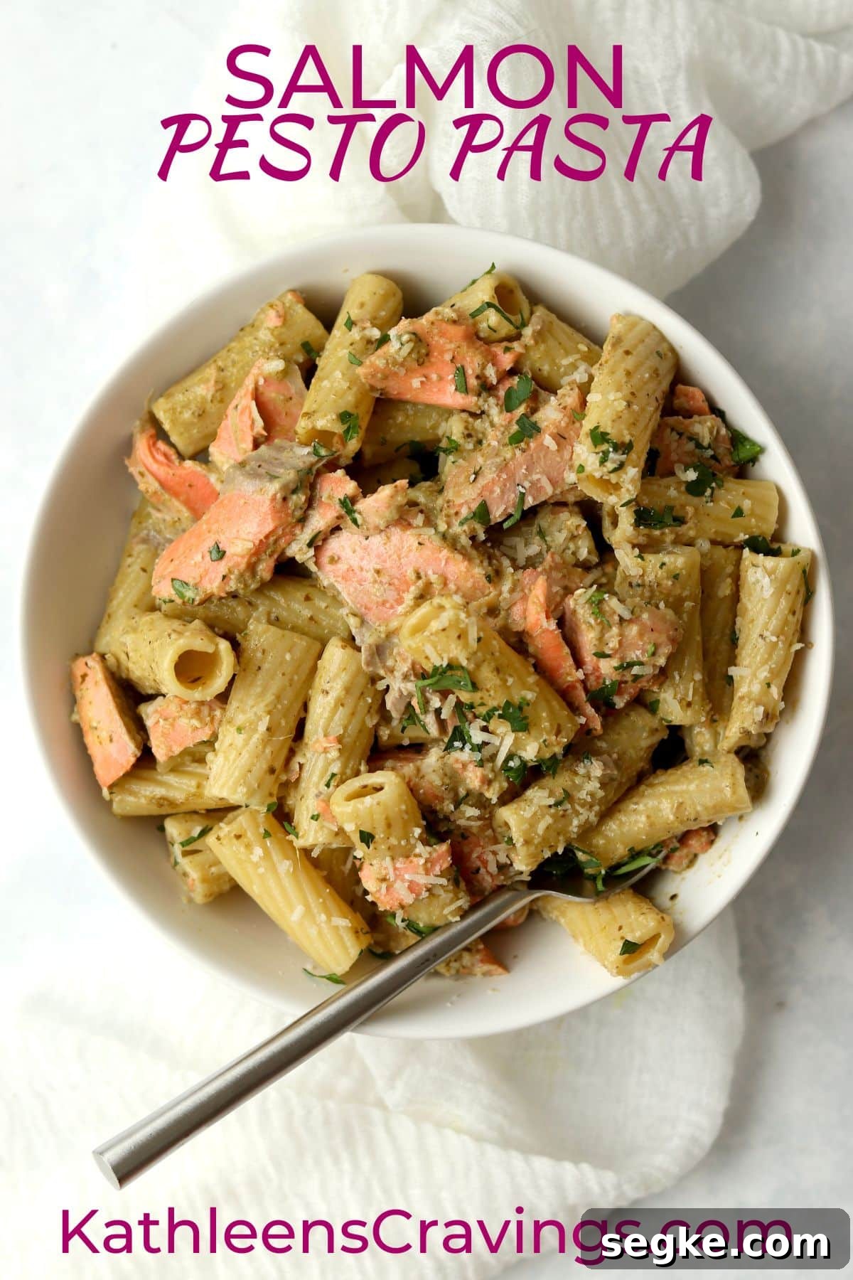 salmon pesto pasta in a bowl with parmesan.