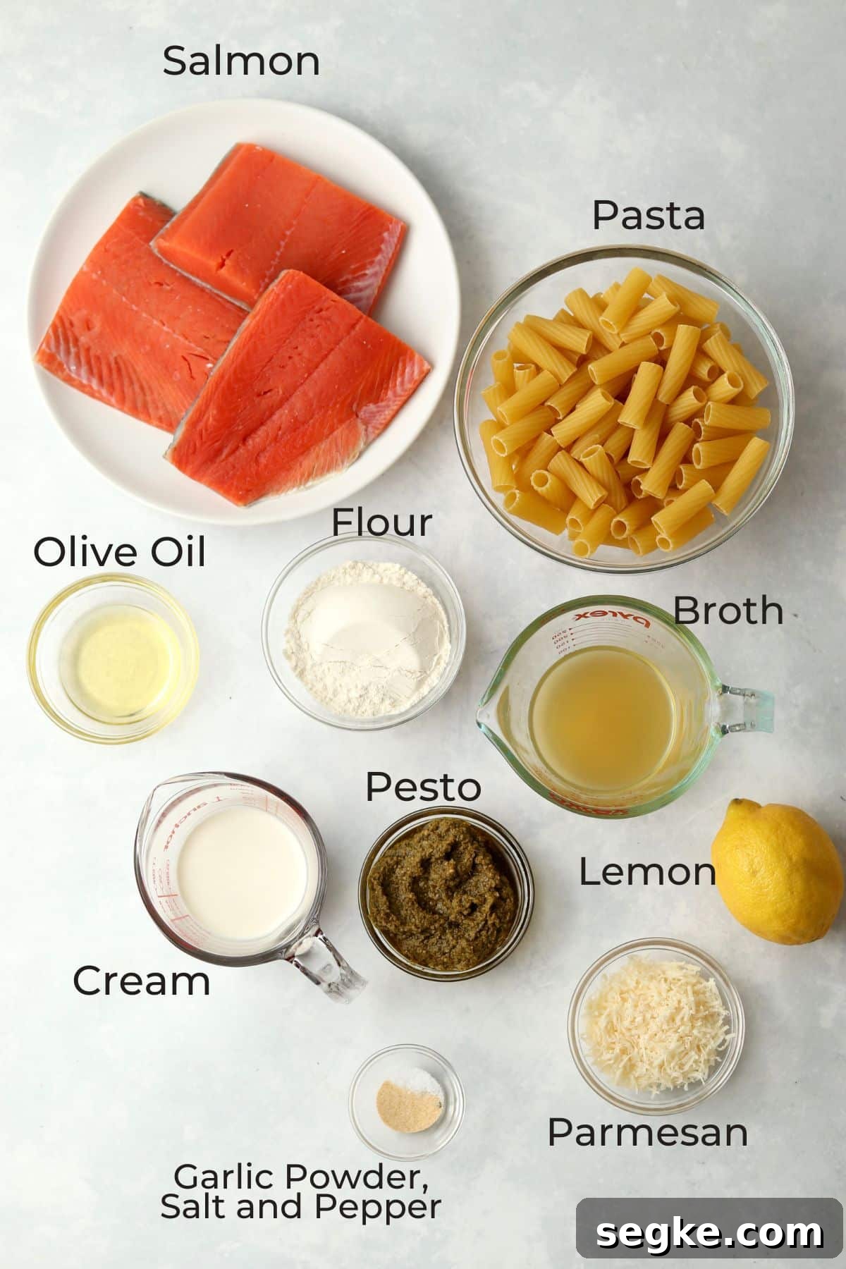 salmon, pasta, flour, broth, oil, pesto, cream, parmesan, lemon, and spices in glass prep bowls