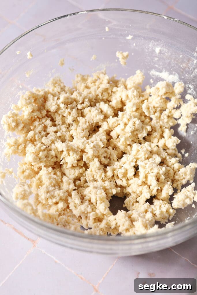a crumbly pie crust in a bowl on a light purple surface
