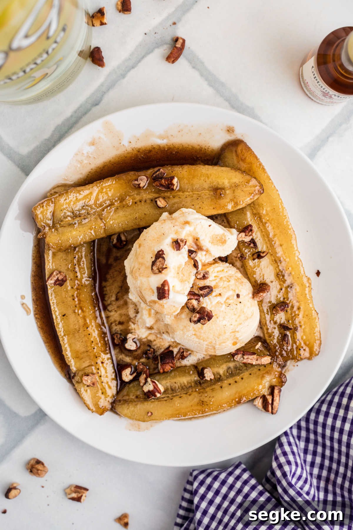 Classic New Orleans Bananas Foster Recipe 2 Overhead shot of a plate of Bananas Foster, with some ice cream in the middle and toasted pecans.