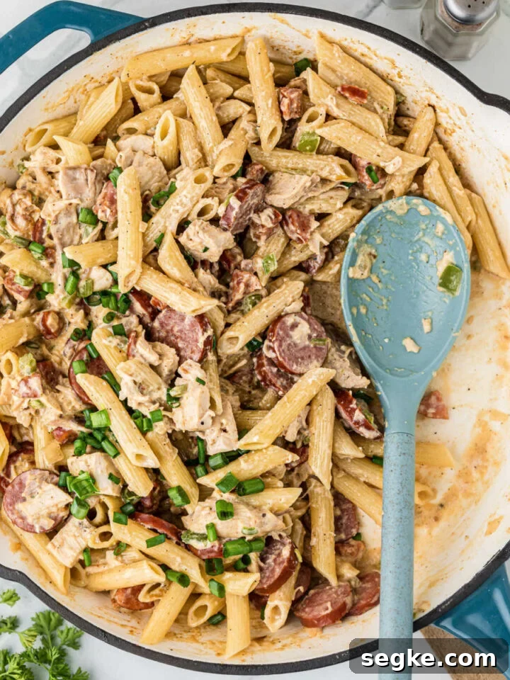 A large skillet filled with Cajun Chicken and Sausage pasta.