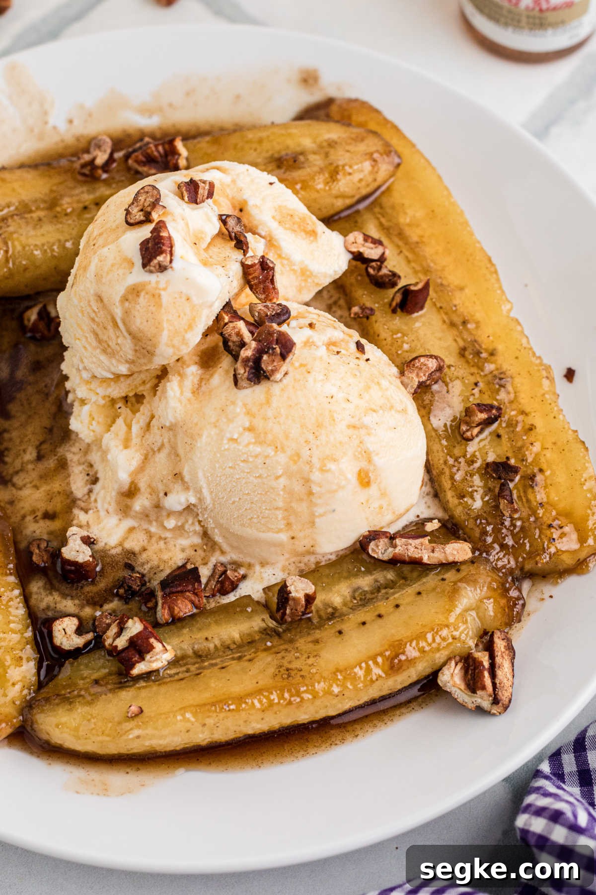 Classic New Orleans Bananas Foster Recipe 5 Side angle of a plate of bananas foster with ice cream.