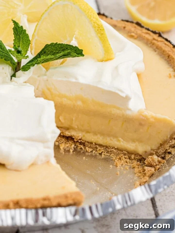 Square cropped shot of the inside of a southern lemon pie with some cream and lemon slices on top.