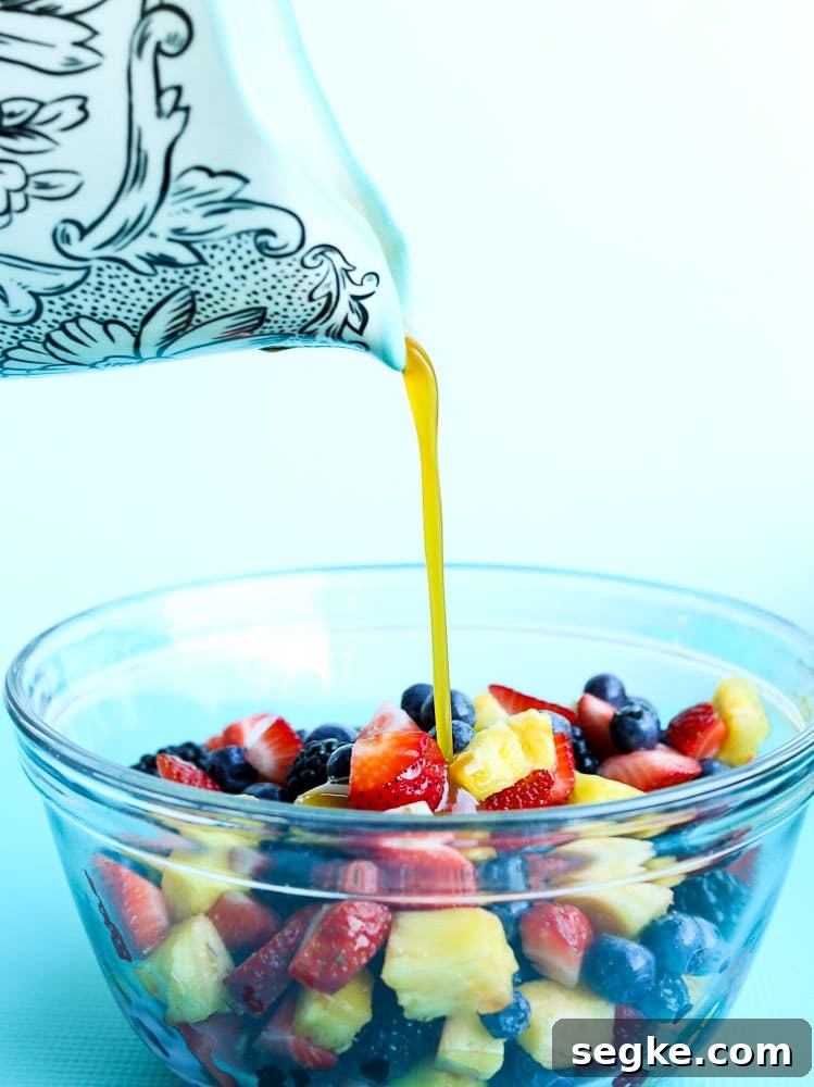 Pouring the Citrus-Honey Sauce onto the Summer Fruit Salad