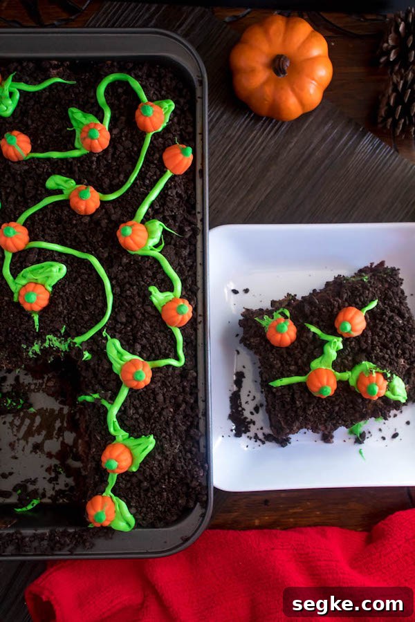 Decorating the cake with crushed Oreos and pumpkin candies
