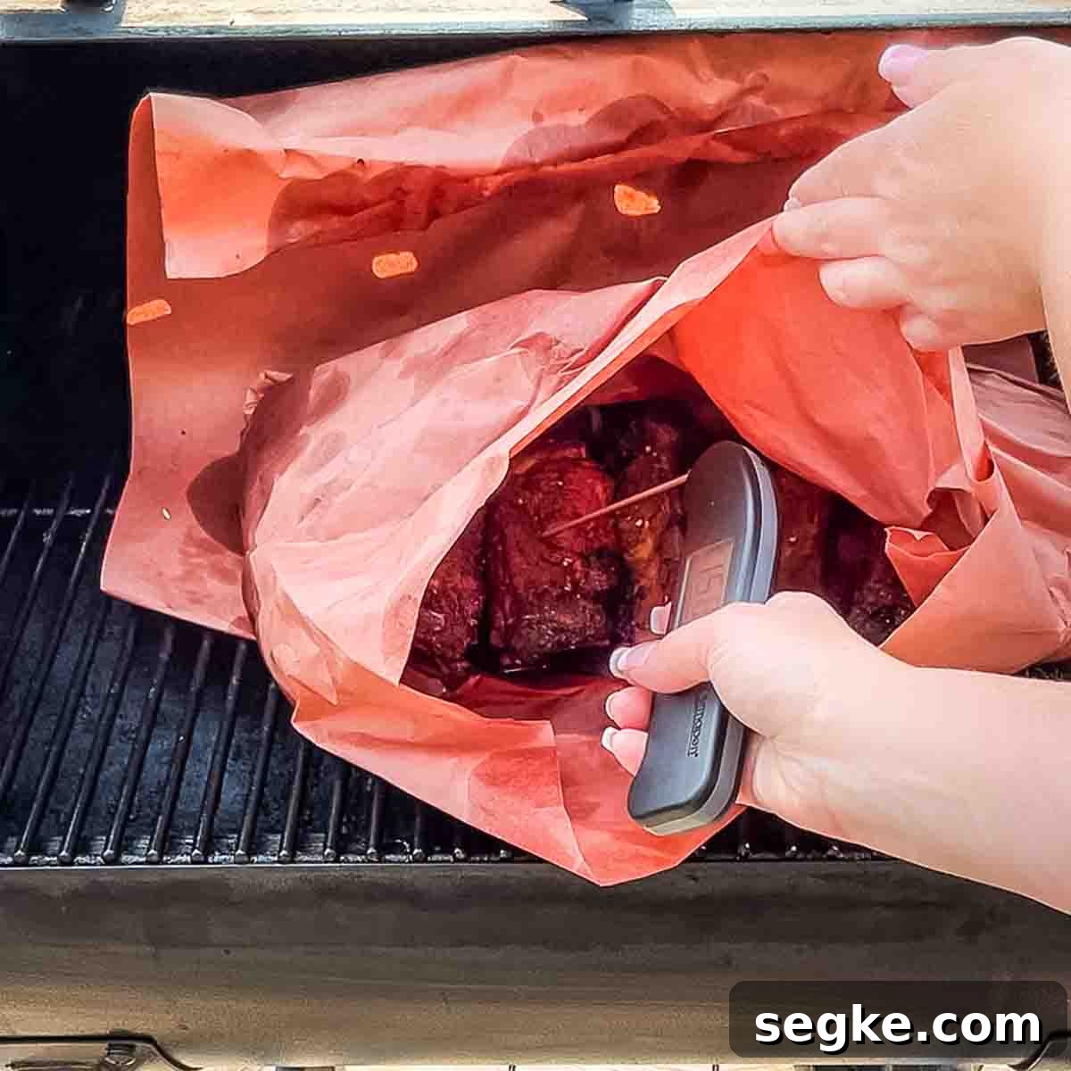How to Smoke Beef Back Ribs on a Pellet Grill 13 A hand using an instant-read thermometer to check the internal temperature of the wrapped ribs.
