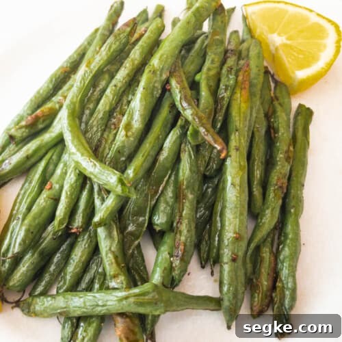 Green Beans on white plate with lemon wedge