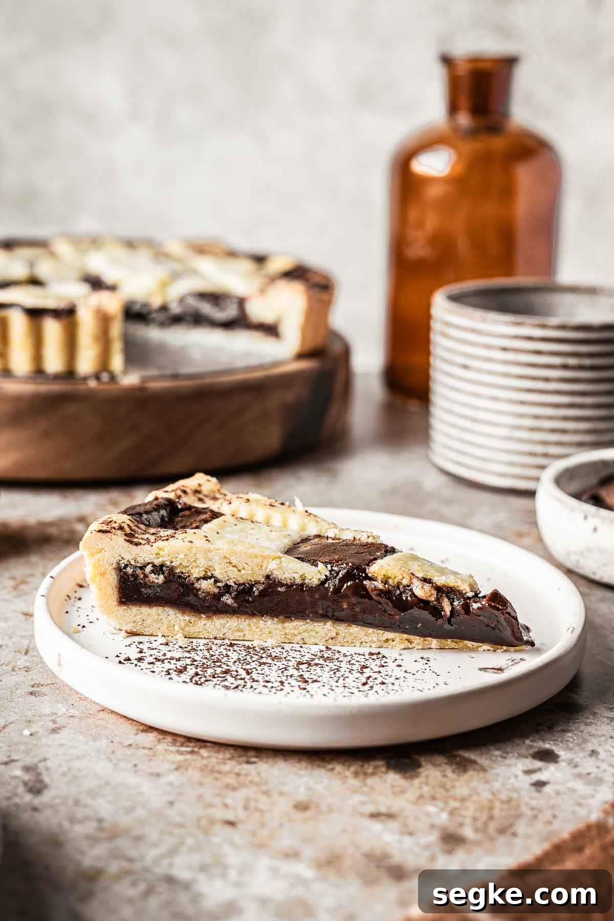 Nutella Crostata: Italian Hazelnut Chocolate Tart Recipe 3 A single slice of crostata alla nutella on a white plate