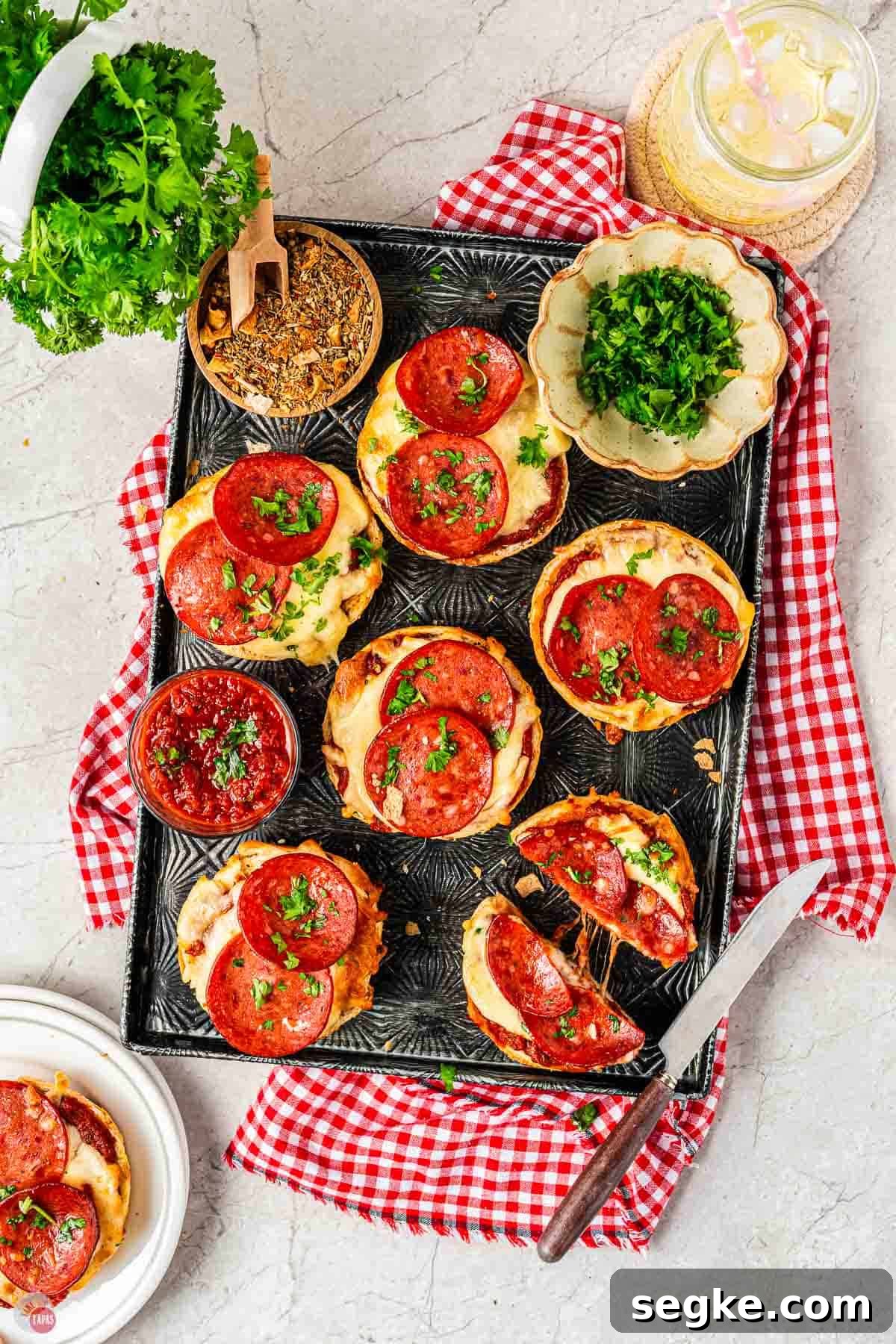 Crispy Air Fryer Pizza Bagels Recipe 2 black tray with air fryer pizza bagels on it topped with pepperoni