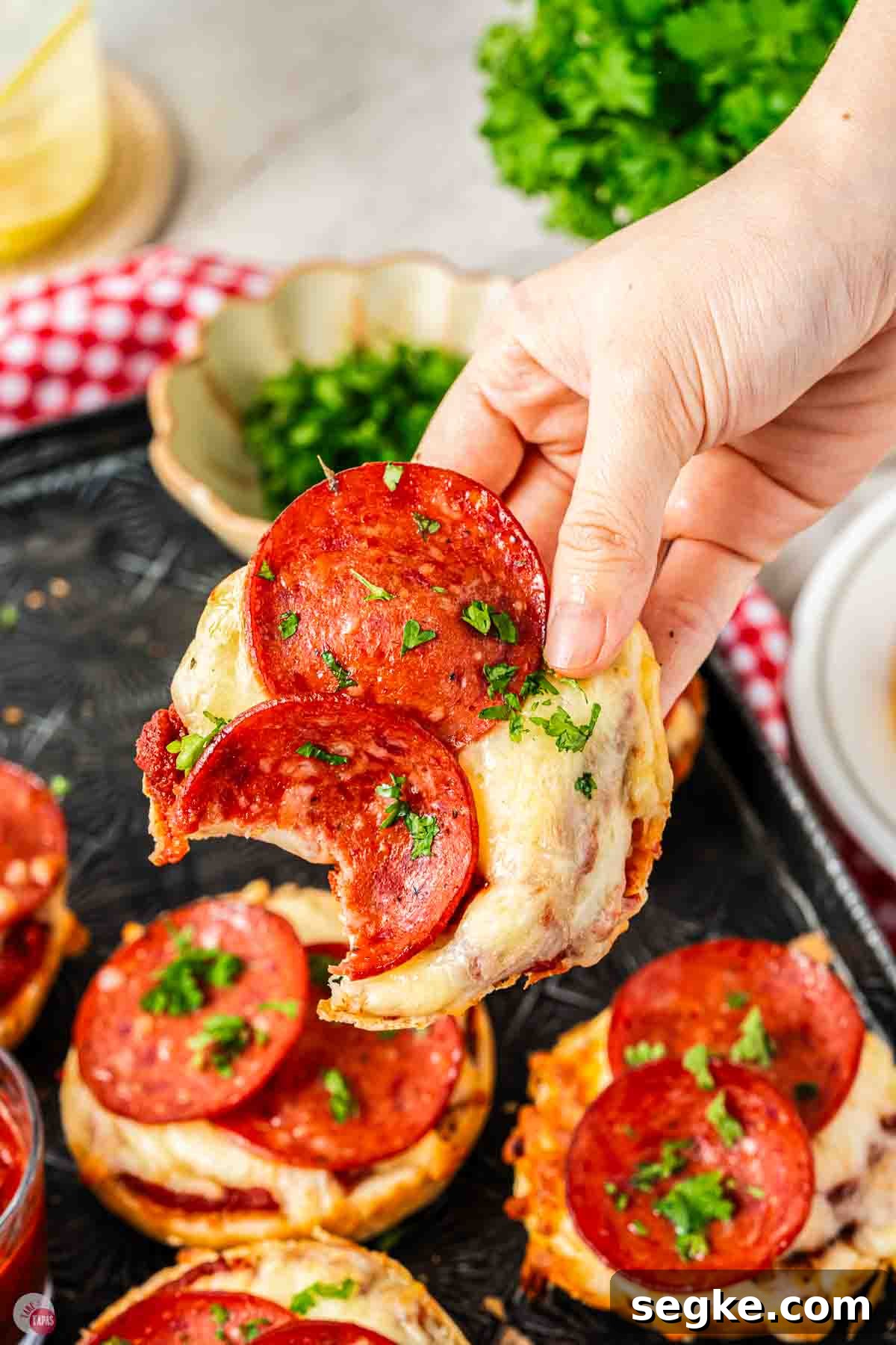 Crispy Air Fryer Pizza Bagels Recipe 10 hand holding a pepperoni pizza bagel with a bite missing