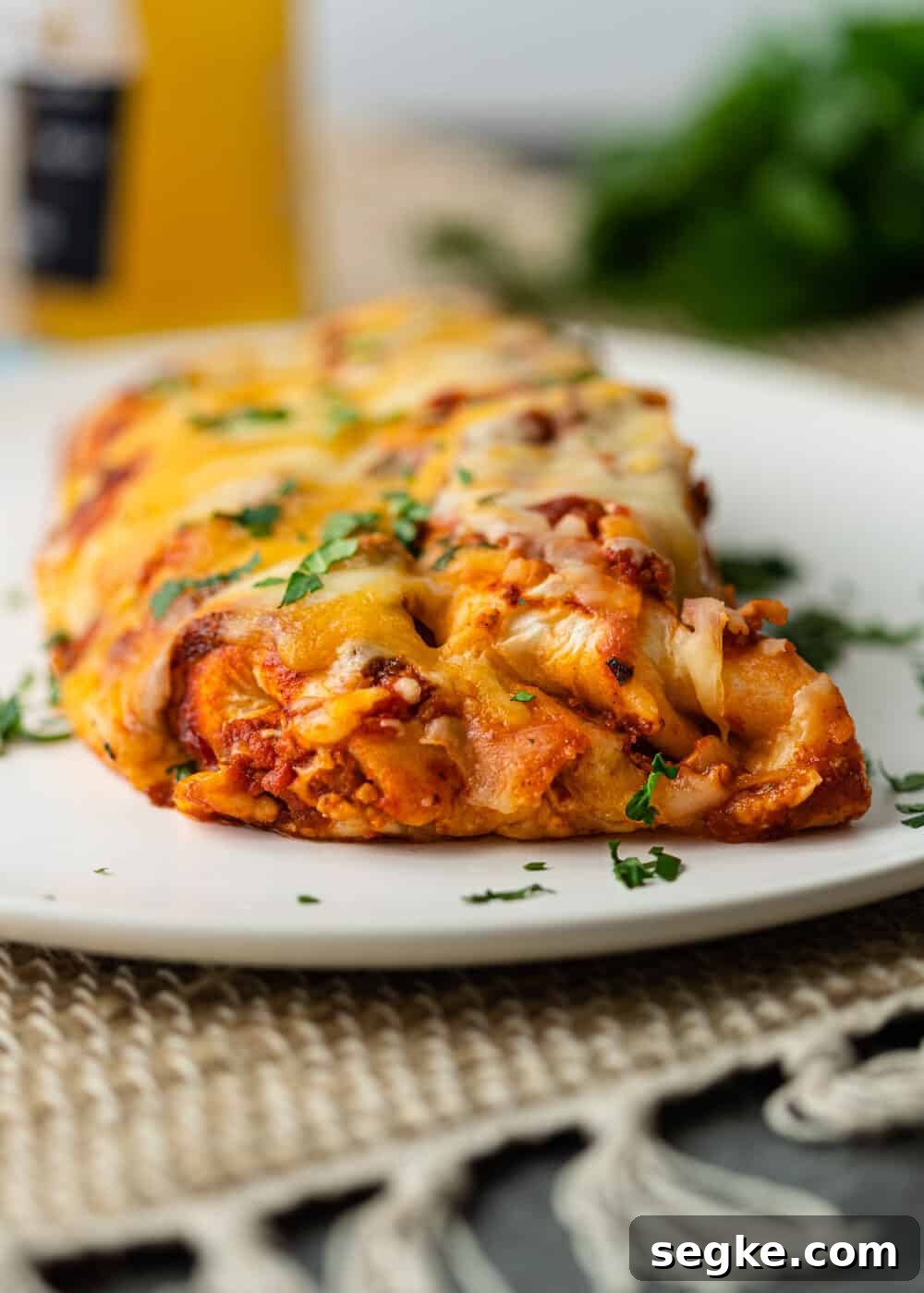 two enchiladas with red sauce on white plate