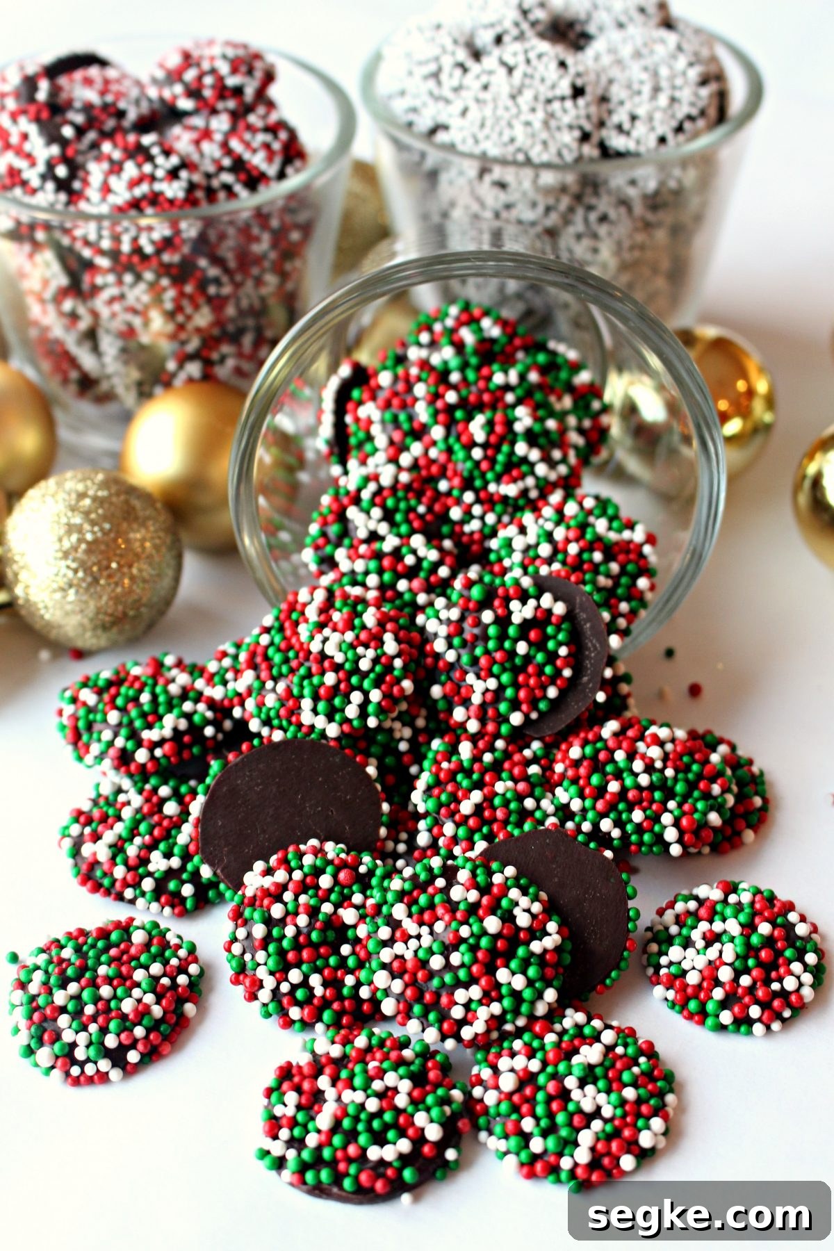 Chocolate Nonpareils: Classic Sprinkle Candy 4 A tipped clear glass spilling out red and green sprinkled chocolates.
