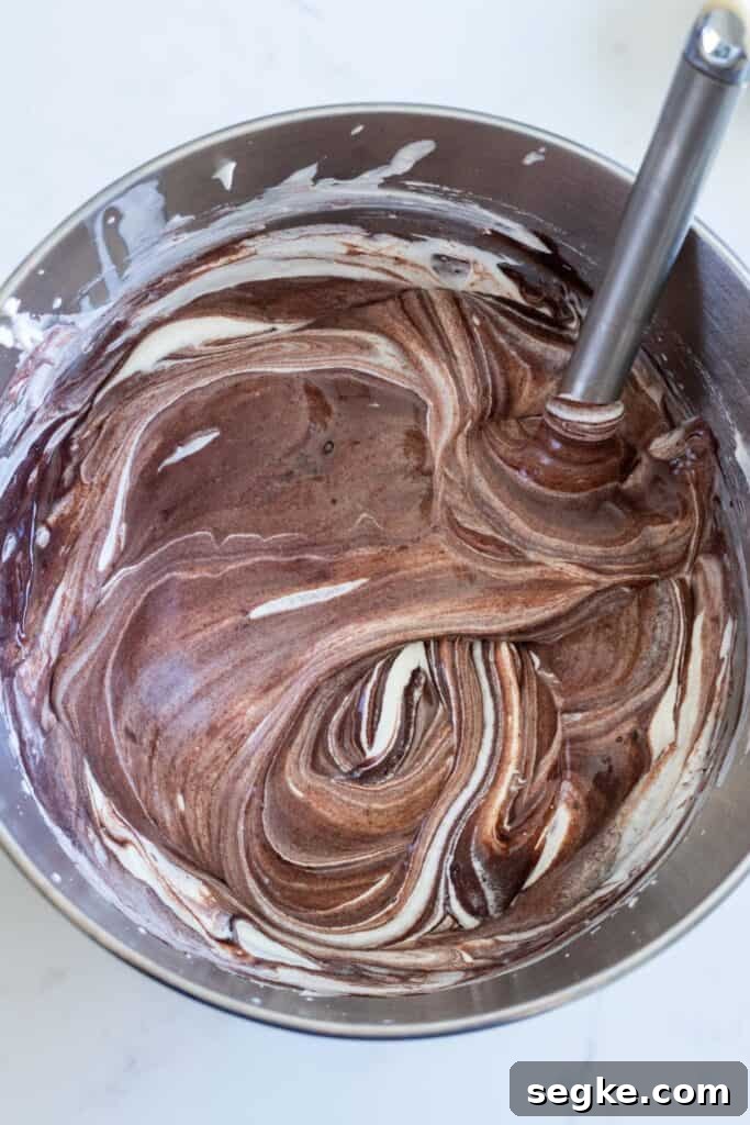 chocolate no-churn ice cream being stirred in metal bowl