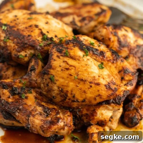 Grilled chicken thighs on a white plate.